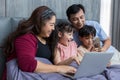 Family time together at home. Happy Family. Happy family and digital technology. family parents and son lying on the bed using sma Royalty Free Stock Photo