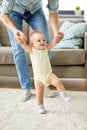 Father helping baby daughter with walking at home Royalty Free Stock Photo