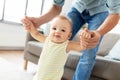 Father helping baby daughter with walking at home Royalty Free Stock Photo