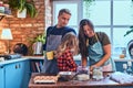 Family together cooking breakfast in loft style kitchen. Royalty Free Stock Photo