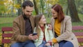 Family together happy man father woman mother child kid girl little daughter outdoors park on bench dad mom baby using Royalty Free Stock Photo