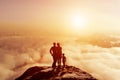 Family together on mountain looking on sunset cloudscape