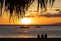 Family of tourists sitting on the beach watching the beautiful Hawaiian sunset Royalty Free Stock Photo