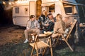 Family trailer travel.Children,brother sister,mom dad playing guitar,singing song at fire.Evening picnic in nature Royalty Free Stock Photo
