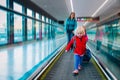 Family on travalator in airport, little girl with mother and sister travel together