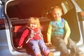 Family travel - little boy and toddler girl with luggage in the car Royalty Free Stock Photo