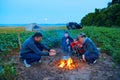 Family traveling and camping, twilight, cooking on the fire. Beautiful nature - field, forest and moon