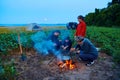 Family traveling and camping, twilight, cooking on the fire. Beautiful nature - field, forest and moon Royalty Free Stock Photo