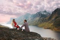 Family traveling in Norway man and woman with infant baby relaxing with mountains and fjord view