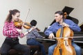 Family trio rehearsing. Father plays the cello, daughter is a violinist, mother plays the piano Royalty Free Stock Photo