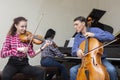 Family trio rehearsing. Father plays the cello, daughter is a violinist, mother plays the piano Royalty Free Stock Photo