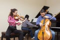 Family trio rehearsing. Father plays the cello, daughter is a violinist, mother plays the piano Royalty Free Stock Photo