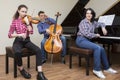 Family trio rehearsing. Father plays the cello, daughter is a violinist, mother plays the piano Royalty Free Stock Photo