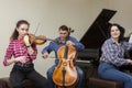 Family trio rehearsing. Father plays the cello, daughter is a violinist, mother plays the piano Royalty Free Stock Photo