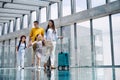 Family with two children going on holiday, walking at the airport with luggage. Royalty Free Stock Photo