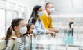 Family with two children going on holiday, wearing face masks at the airport. Royalty Free Stock Photo