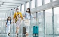 Family with two children going on holiday, wearing face masks at the airport. Royalty Free Stock Photo