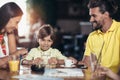 Family with two children having great time in a cafe after shop Royalty Free Stock Photo