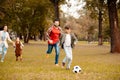 Family with two children running and playing soccer together in an Royalty Free Stock Photo