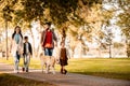 Family with two children walking down the road in autumn park Royalty Free Stock Photo