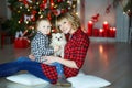 Family of two people mother and on new year& x27;s eve near the decorated Christmas tree sitting on the floor with a small Royalty Free Stock Photo