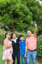 Family with two teenagers use a cell phone to take a selfie Royalty Free Stock Photo