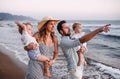 A family with two toddler children walking on beach on summer holiday at sunset. Royalty Free Stock Photo