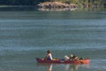 Family of two together with their best friend dog and cuddles in rowing boat in lush green forest lake in BC Royalty Free Stock Photo