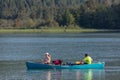 Family of two together with their best friend dog in rowing boat in lush green forest lake in BC on a summer vacation Royalty Free Stock Photo