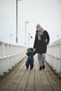 A family of two is walking on a pier