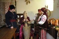 Family in Ukrainian native costumes gathered to cook traditional dish kutia for celebrating Christmas Eve. Ukrainian