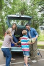 Family unloading car trunk while on picnic Royalty Free Stock Photo