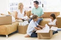 Family unpacking boxes in new home smiling