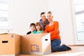 Family unpacking moving boxes in new home Royalty Free Stock Photo