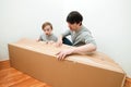 Family unpacking moving boxes in new home. Dad and son opening together boxes. Moving house day Royalty Free Stock Photo