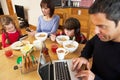 Family Using Gadgets Whilst Eating Breakfast Royalty Free Stock Photo