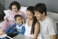 Family Using Laptop on Couch Royalty Free Stock Photo