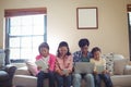 Family using laptop, digital tablet and mobile phone in living room Royalty Free Stock Photo
