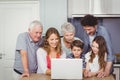 Family using laptop in kitchen Royalty Free Stock Photo
