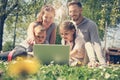 Family using laptop, sitting on the green grass. Family en Royalty Free Stock Photo