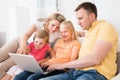Family using laptop on sofa Royalty Free Stock Photo