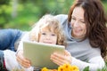 Family using tablet PC outdoors Royalty Free Stock Photo