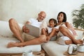 Family Using Tablet On Weekend. Happy Interracial Parents With Little Boy Sitting On Sofa, Using Digital Device At Home. Royalty Free Stock Photo
