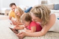 Family using tablets lying on carpet