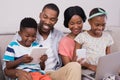Family using technologies while sitting on sofa at home Royalty Free Stock Photo