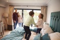 Family On Vacation With Children Playing On Hotel Bed Royalty Free Stock Photo