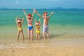 Family vacation on Christmas and New Year holidays, happy parents and children in santa hats have fun on beach Royalty Free Stock Photo