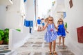 Family vacation in Europe. Parents and kids at street of typical greek traditional village on Mykonos Island, in Greece Royalty Free Stock Photo