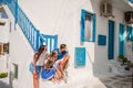 Family vacation in Europe. Parents and kids at street of typical greek traditional village with white walls and colorful Royalty Free Stock Photo