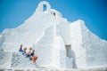 Family vacation in Europe. Parents and kids at street of typical greek traditional village with white walls and colorful Royalty Free Stock Photo